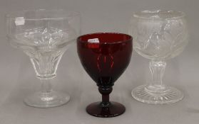 An engraved glass goblet, together with two others. The largest 18 cm high.