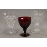 An engraved glass goblet, together with two others. The largest 18 cm high.