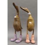 Two wooden ducks, in boots. The largest 49.5 cm high.