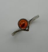 An amber set unmarked silver ring. Ring Size O/P.