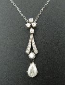 An unmarked white gold or platinum diamond set drop pendant on chain. The drop approximately 0.