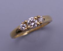 A vintage 18 ct gold three stone diamond ring. Centre stone approximately 0.20 carats.