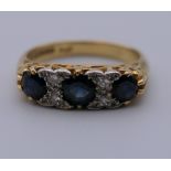 An 18 ct gold diamond and sapphire ring. Ring size K. 4.9 grammes total weight.