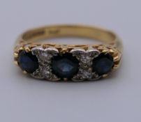 An 18 ct gold diamond and sapphire ring. Ring size K. 4.9 grammes total weight.