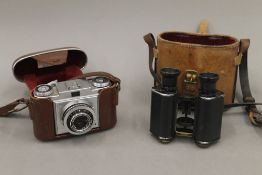 A cased set of binoculars and a Zeiss Ikon camera. The former 13 cm high.