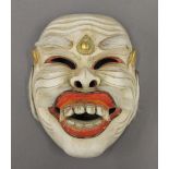 An Indonesian carved and painted street players mask, with the interior inscribed. 18.5 cm high.