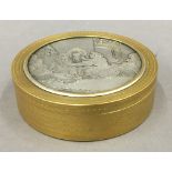 A 19th century gilt circular box, the lid with engraved silver plated panel. 9.75 cm diameter.