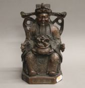 A Chinese bronze model of an Emperor holding a censer. 23 cm high.