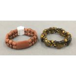 A goldstone bracelet and a tigers eye bracelet.