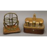 An early 20th century brass mounted letter rack and a leather cased set of perfume bottles.