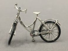 A small silver model of a bicycle. 6 cm wide.