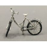 A small silver model of a bicycle. 6 cm wide.