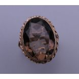A 9 ct gold topaz/smoky quartz ring. Ring size L/M. 6.2 grammes total weight.