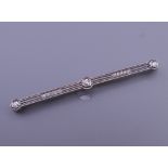 An Art Deco platinum diamond bar brooch with an 18 ct gold pin. 6 cm long. 5.6 grammes total weight.