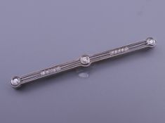 An Art Deco platinum diamond bar brooch with an 18 ct gold pin. 6 cm long. 5.6 grammes total weight.