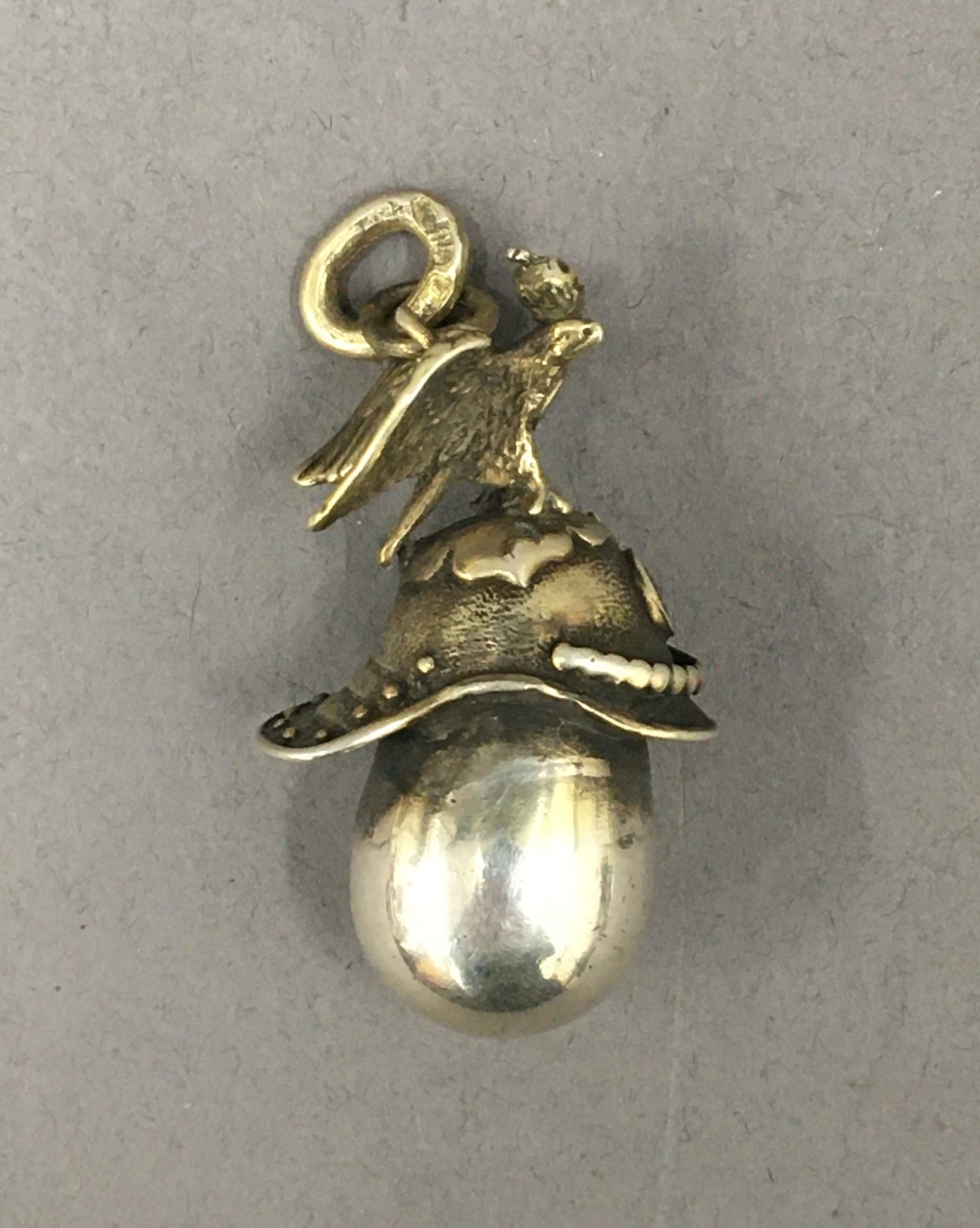A pendant formed as a Russian helmet and egg. 3.5 cm high.