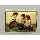 A silver snuff box decorated with children. 4.5 cm wide.
