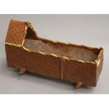 A 19th century treacle glazed pottery crib. 45 cm long.