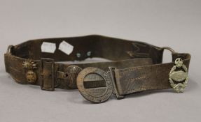 A vintage Boy Scouts leather belt set with military cap badges. 82 cm long.
