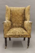 A 19th century upholstered wing back armchair. 73 cm wide.