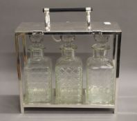 A Three bottle silver plated tantalus. 28 cm wide.