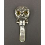 A silver rattle formed as an owl. 7 cm high.