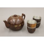 A carved coconut teapot and four cups. The teapot 10 cm high.