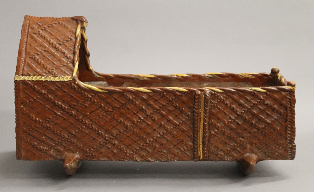 A 19th century treacle glazed pottery crib. 45 cm long. - Image 2 of 4