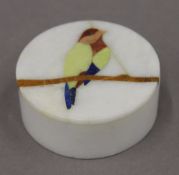 A small onyx box, inlaid with a bird. 7 cm diameter.