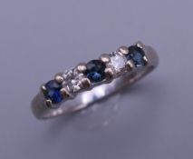 A 18 ct white gold sapphire and diamond band. Diamond weight stamped to the inside of ring, 0.