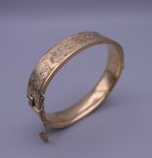 A 9 ct gold bangle form bracelet. 6.5 cm wide. 19.6 grammes.