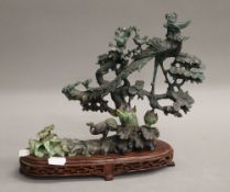 A jade bird group on wooden base. 24 cm high.