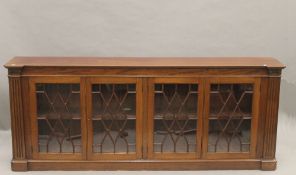 An early 20th century glazed mahogany dwarf bookcase. 195 cm long, 78 cm high, 22.5 cm deep.