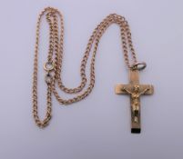 A 9 ct gold crucifix on a 9 ct gold chain. 3 cm high. 10.6 grammes.