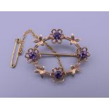 A 9 ct gold and amethyst brooch. 3.25 cm wide. 3.9 grammes total weight.