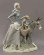 A Lladro porcelain group formed as a woman, a child and a donkey. 35 cm high.