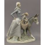 A Lladro porcelain group formed as a woman, a child and a donkey. 35 cm high.