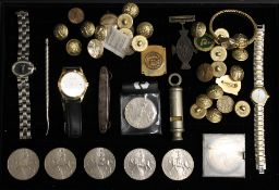 A display case containing a 1930s police whistle, crowns, vintage buttons, RAF badges, etc.