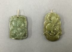 Two small jade pendants with gold loops. The largest 3 cm high.