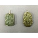 Two small jade pendants with gold loops. The largest 3 cm high.