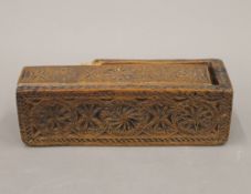 An antique carved treen box. 17 cm long.