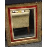 A gilt and red velvet framed wall glass. 82 x 66.5 cm.