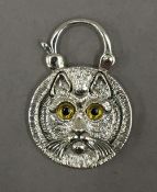 A silver and abalone cat padlock. 2.5 cm diameter.