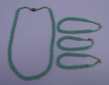 A vintage green coral necklace and three bracelets. The former 42 cm long.