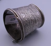 An antique Afghan unmarked silver bracelet with tooled patterning. 5 cm diameter.