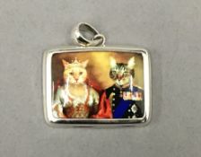 A silver pendant decorated with cats. 3 cm wide.