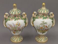 A pair of 19th century hand painted porcelain urns and covers. 32 cm high.