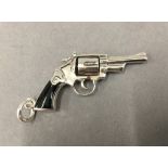 A pendant formed as a revolver. 5.5 cm long.