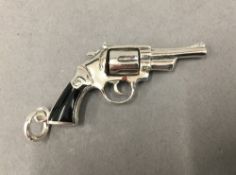 A pendant formed as a revolver. 5.5 cm long.