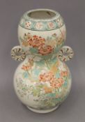 A 19th century Oriental pottery double gourd vase, brightly decorated with flowers and rockwork. 31.